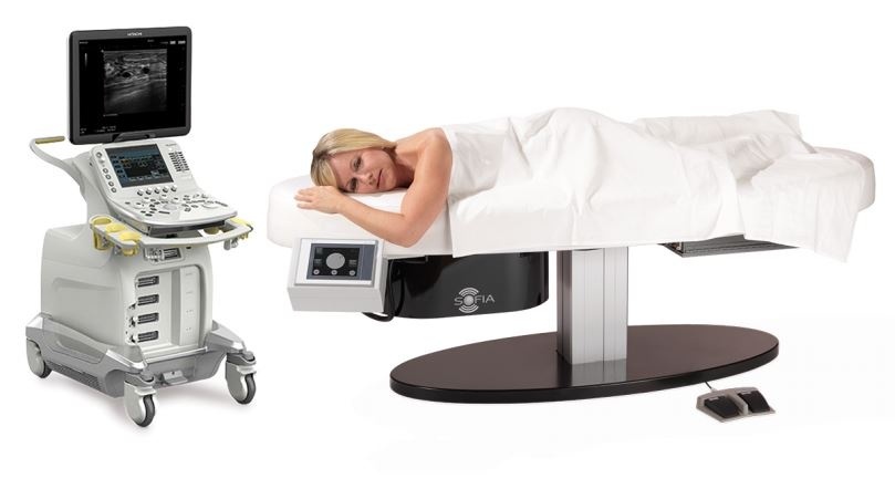 Product photo of the ultrasound system with a woman lying on the table