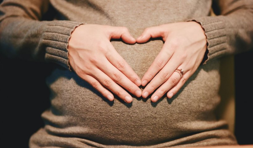 pregnant woman holding her hands over her belly