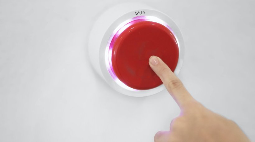 finger pushing a big red button
