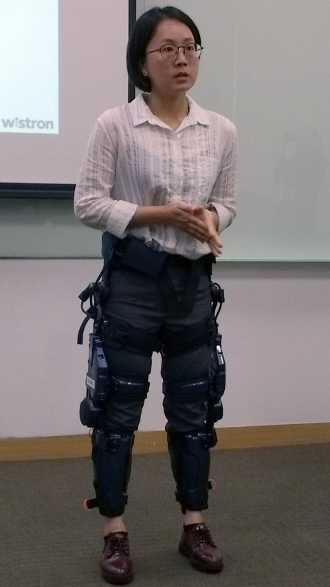 woman with robotic exoskeleton standing next to man in business suit