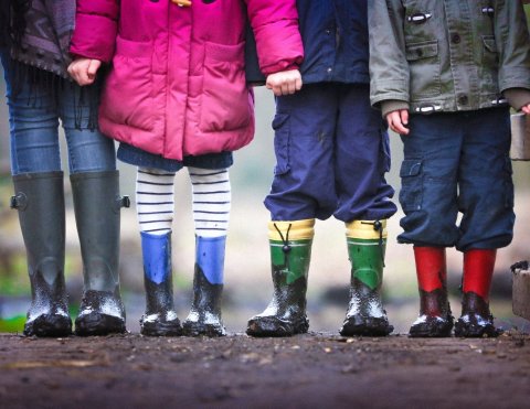 four children wearing muddy boots