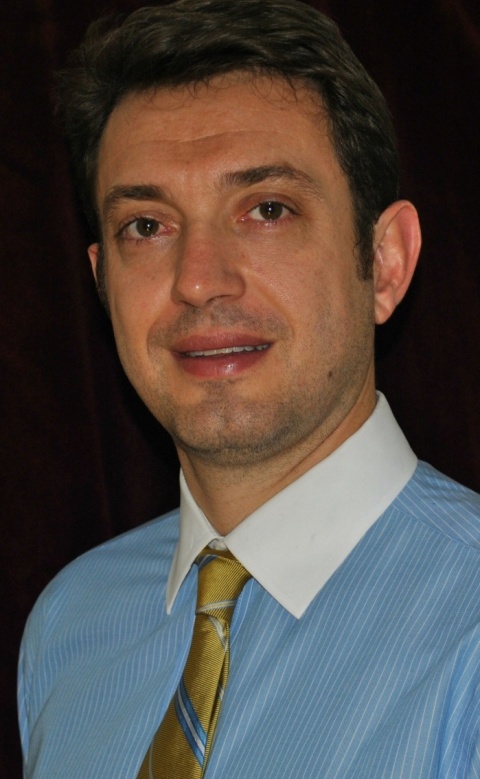 Dr Marcio Sommer Bittencourt wears a blue shirt and a golden tie.