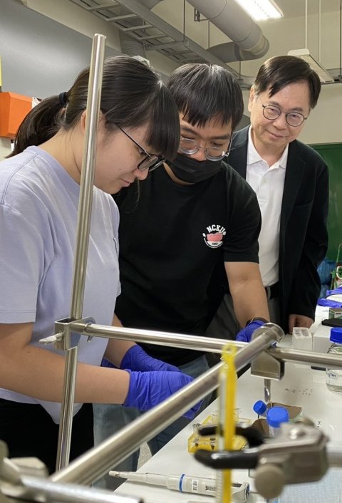Three researchers performing an experiment in a laboratory setting